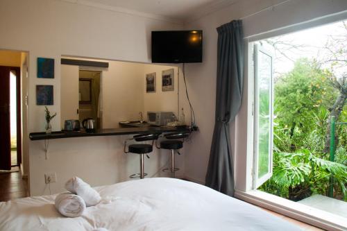 een slaapkamer met een bed en een groot raam bij The Manor House in Sir Lowry Pass