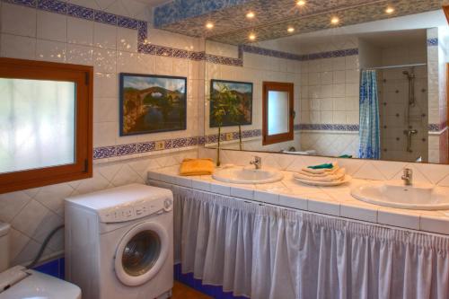 y baño con 2 lavabos y lavadora. en ViVaTenerife - Retreat in nature, SPA and wellness en Tejina de Isora