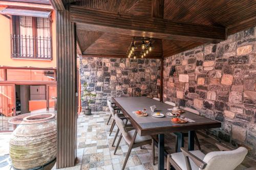 a dining room with a table and chairs and a brick wall at CASA MİSYA in Bursa