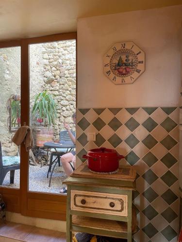 une cuisine avec un comptoir et une horloge au mur dans l'établissement Maison Flamingo, à Saint-Geniès-de-Fontedit