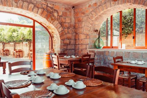 a dining room with tables and chairs and windows at COUNTRY HOUSE LE VIGNE b&b in Galluccio