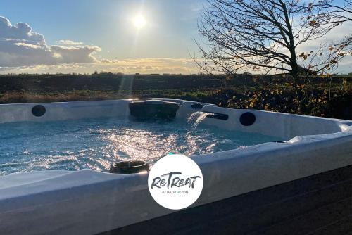 a jacuzzi tub with the sun in the background at ReTreat Breaks - 45 Park Lane in Patrington