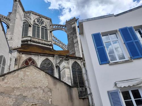 een kerk met blauwe luiken en een gebouw bij Bienvenue in Auxerre