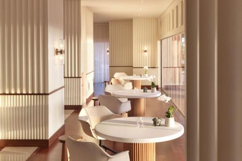 a restaurant with white tables and white chairs at The Ritz-Carlton Tenerife, Abama in Guía de Isora