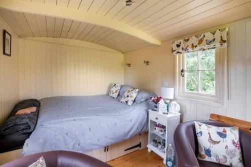 a bedroom with a bed in a small room at Shepherds Hut at The Retreat in Oswestry