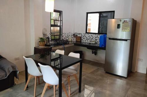 cocina con mesa y nevera en Yannas transient house en Roxas City