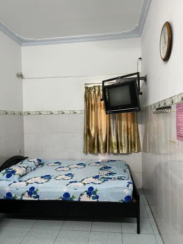 a bedroom with a bed and a tv on the wall at Cát Phượng Motel in Phan Thiet