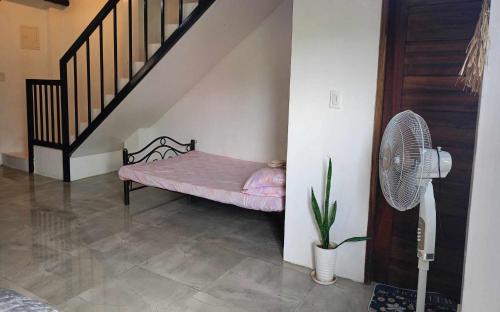 małe łóżko w pokoju z wentylatorem w obiekcie Yannas transient house w mieście Roxas