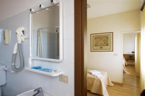 a bathroom with a phone and a mirror on the wall at Hotel Roma in Ravenna