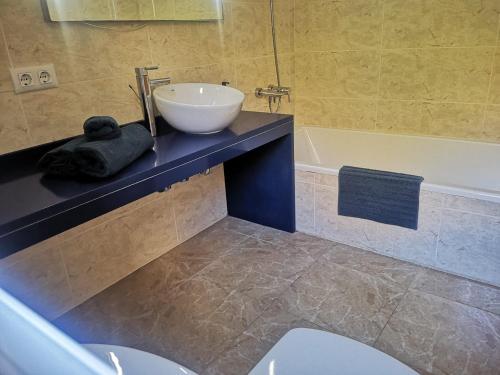 a bathroom with a sink and a toilet and a tub at Casa Hokie in Colonia de Sant Pere