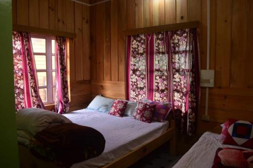 - une chambre avec un lit et des rideaux roses dans l'établissement MECHUKA Homes, à Mechuka