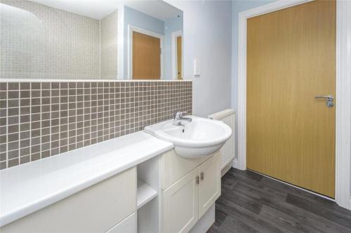 a white bathroom with a sink and a mirror at The apartment in West Rainton