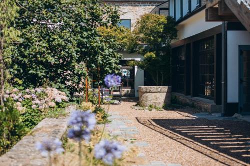 a garden with purple flowers in front of a building at Bigouden Makers in Pont-lʼAbbé