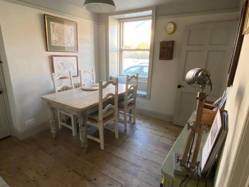 una sala da pranzo con tavolo e sedie in legno di Quirky Victorian Cottage in Shaldon Devon a Shaldon