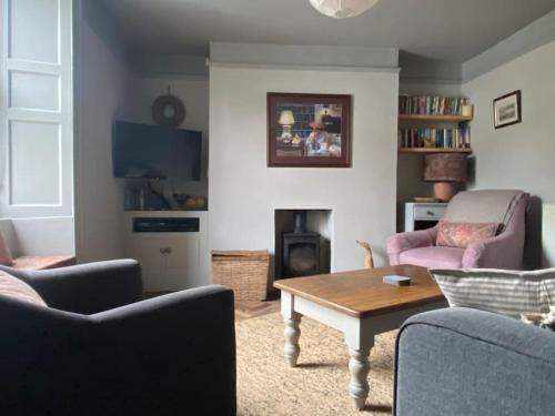 ein Wohnzimmer mit 2 Sofas und einem Tisch in der Unterkunft Quirky Victorian Cottage in Shaldon Devon in Shaldon
