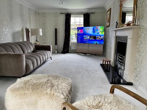 een woonkamer met een bank en een tv bij Four bedroom entire luxury house in wynyard with free wi-fi, Parking and lots more 