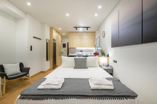 1 dormitorio con 1 cama blanca grande y 1 silla en Seaside Serenity: Charming Studio Flat, en Atenas