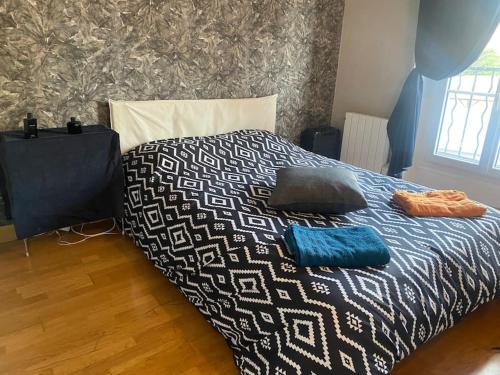 ein Bett mit zwei Kissen darüber in der Unterkunft Appartement à Paris in Le Raincy