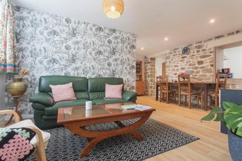 un salon avec un canapé vert et une table dans l'établissement La Bellevue Bréville - B&B, à Bréville-sur-Mer