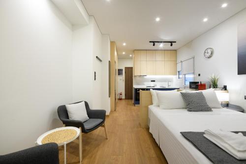 1 dormitorio con 1 cama y 1 silla y cocina en Seaside Serenity: Charming Studio Flat, en Atenas