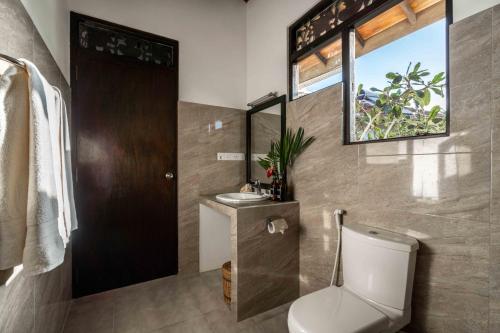 bagno con servizi igienici, lavandino e specchio di Ananthaya Beach a Tangalle