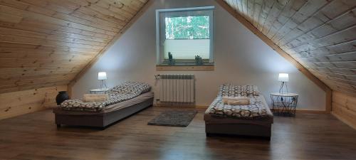 una gran sala de estar con 2 sofás y una ventana en Apartament Świerkowa 11, en Augustów