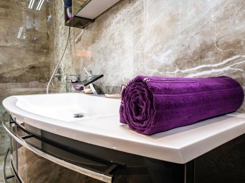 ein lila Handtuch auf einem Waschbecken im Bad in der Unterkunft Luxurious Apartment in Zadar with Garden in Arbanasi