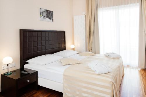 a bedroom with a large bed with white sheets and pillows at Hotel Sandwirth in Klagenfurt