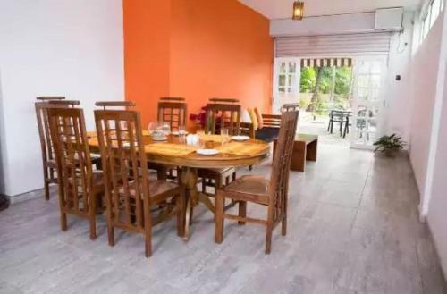 a dining room with a wooden table and chairs at Maggona Beach Villa in Maggona West