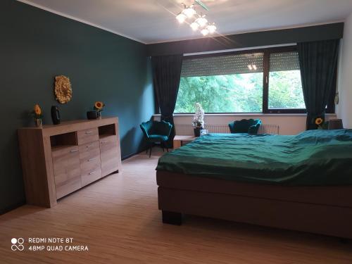 a bedroom with a bed and a window and a dresser at Park Villa Ferienwohnung mit Pool und 3 Schlafzimmer in Uelzen