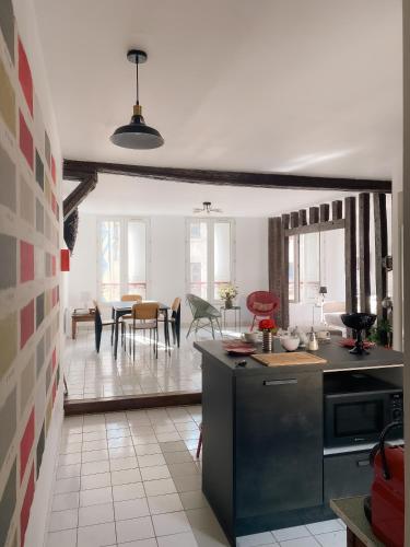 uma cozinha e sala de estar com mesa e cadeiras em Au nom de la rose, beau 3 pièces en centre-ville em Provins
