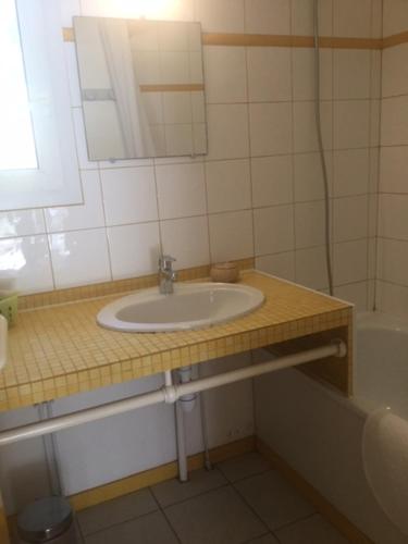 ein Badezimmer mit Waschbecken, Spiegel und Badewanne in der Unterkunft Village Club Dunea in Soustons