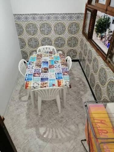 einen Tisch mit 2 Stühlen und einen Tisch mit einer Decke in der Unterkunft المضيق الرينكون in Mʼdik