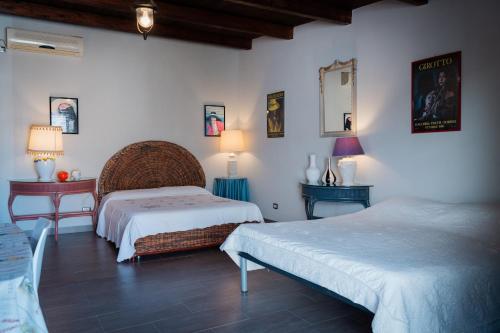 sypialnia z 2 łóżkami oraz 2 stołami i lampami w obiekcie Tenuta De Francisci w mieście Ponte Madonna