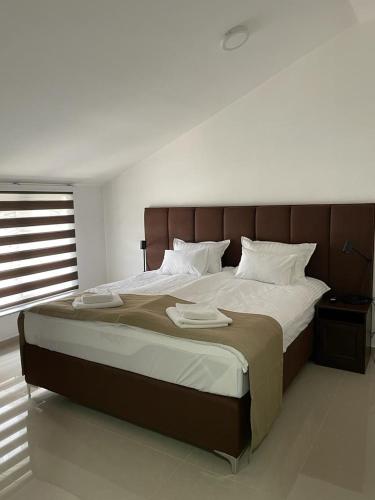 a bedroom with a large bed with two towels on it at Morpheus apartmani in Sremska Mitrovica