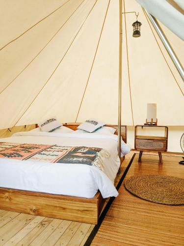 um quarto com uma cama numa tenda em PukuPods - Tent & Cabin em Tabanan