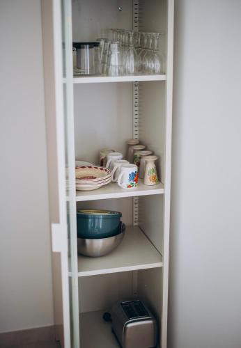 a white pantry with some dishes and a bowl at Bigouden Makers in Pont-lʼAbbé