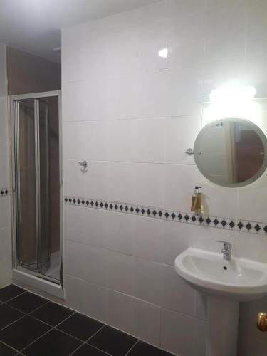 a bathroom with a sink and a mirror and a shower at Aberdeen House in Aberdeen