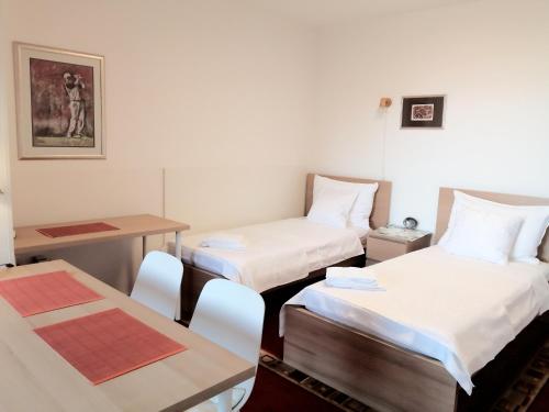 a room with two beds and a table and chairs at Apartment Alea in Portorož