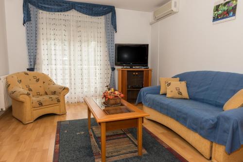 ヘーヴィーズにあるMuskátli Apartmanházのリビングルーム(青いソファ、テーブル付)