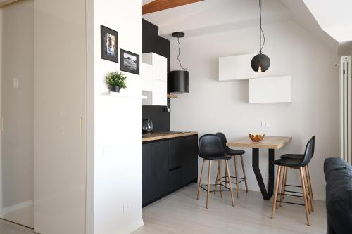 uma cozinha e sala de jantar com uma pequena mesa e cadeiras em Bright attic flat in the centre em Riga