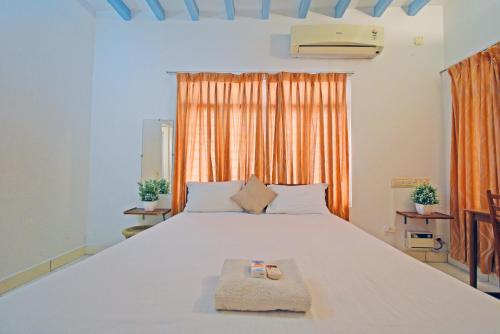 a bedroom with a large white bed in front of a window at Villa Waves in Puducherry