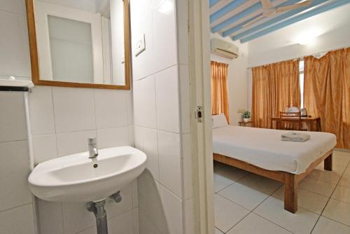 La salle de bains est pourvue d'un lavabo et d'un lit dans la chambre. dans l'établissement Villa Waves, à Pondichéry