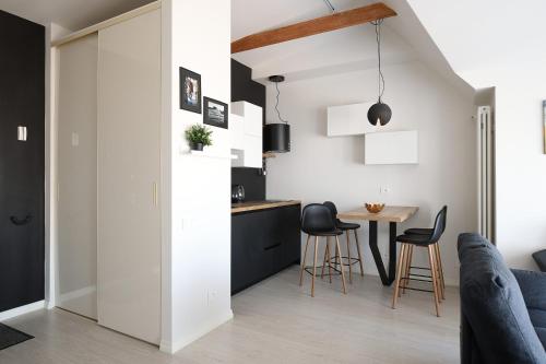 uma cozinha e sala de estar com mesa e cadeiras em Bright attic flat in the centre em Riga