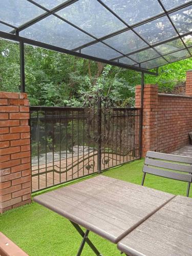 a patio with a picnic table and a fence at Red Stone in Truskavets