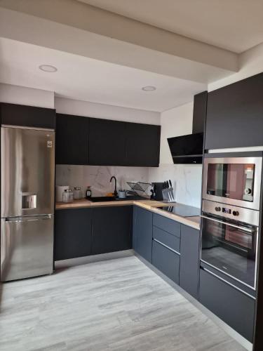a kitchen with blue cabinets and stainless steel appliances at Ocean Paradise do Til in Funchal