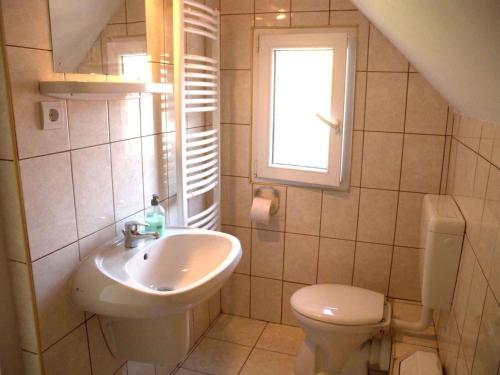 Un baño con lavabo, inodoro y ventana. en Apartment in Siofok - Balaton 35634, en Siófok