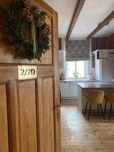 a kitchen with a door with a sign on it at Anny Łajming 2D in Słupsk
