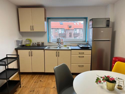 una cucina con lavandino, tavolo e finestra di Central Plaza a Katowice