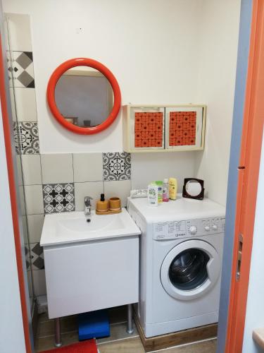 une petite salle de bains avec un lave-linge et un lavabo dans l'établissement The Seventies Appart rétro (proche gare et centre ville), à Amiens